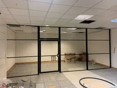 Black mesh enclosure with an access door inside a plant room